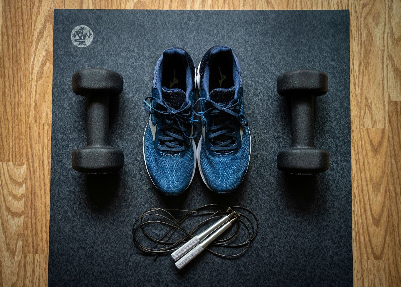 sportschoenen en dumbells met springtouw